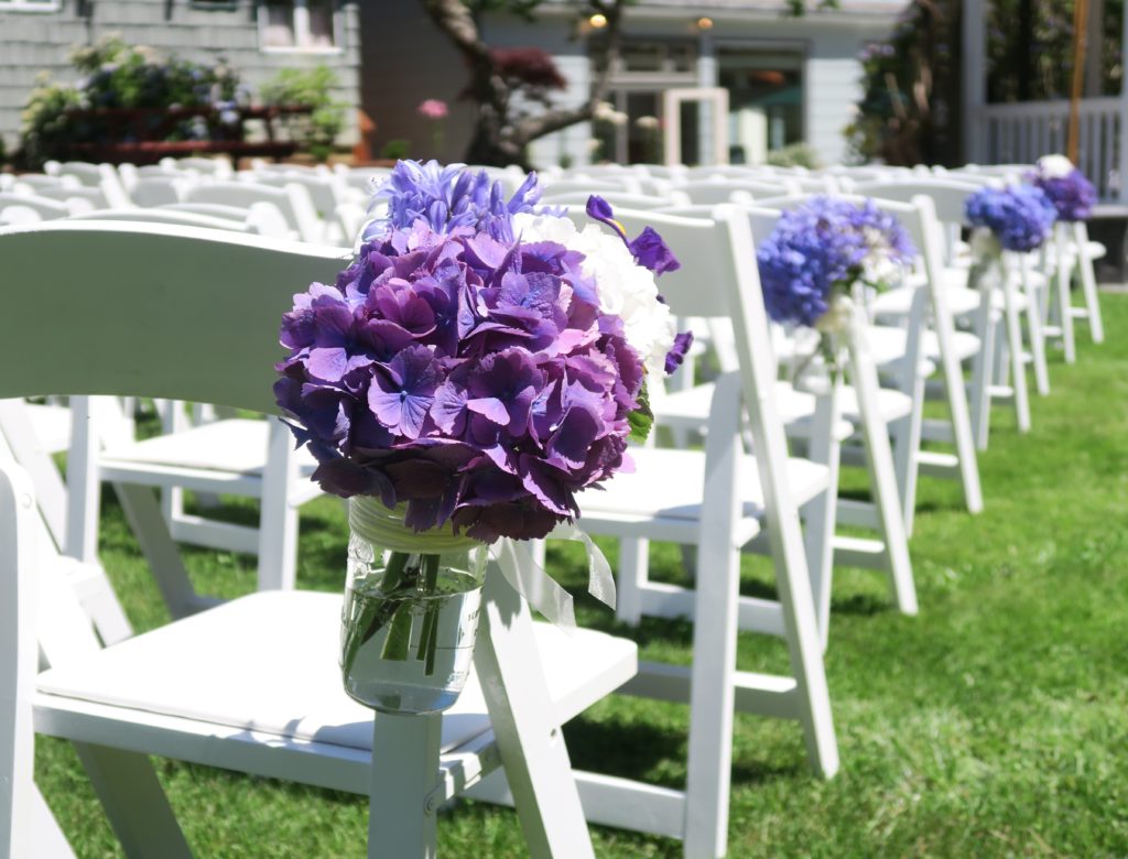 Hydrangeas decorating white chairs ...