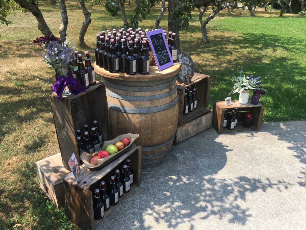 Bottles of cider arranged in front of an orchard ...