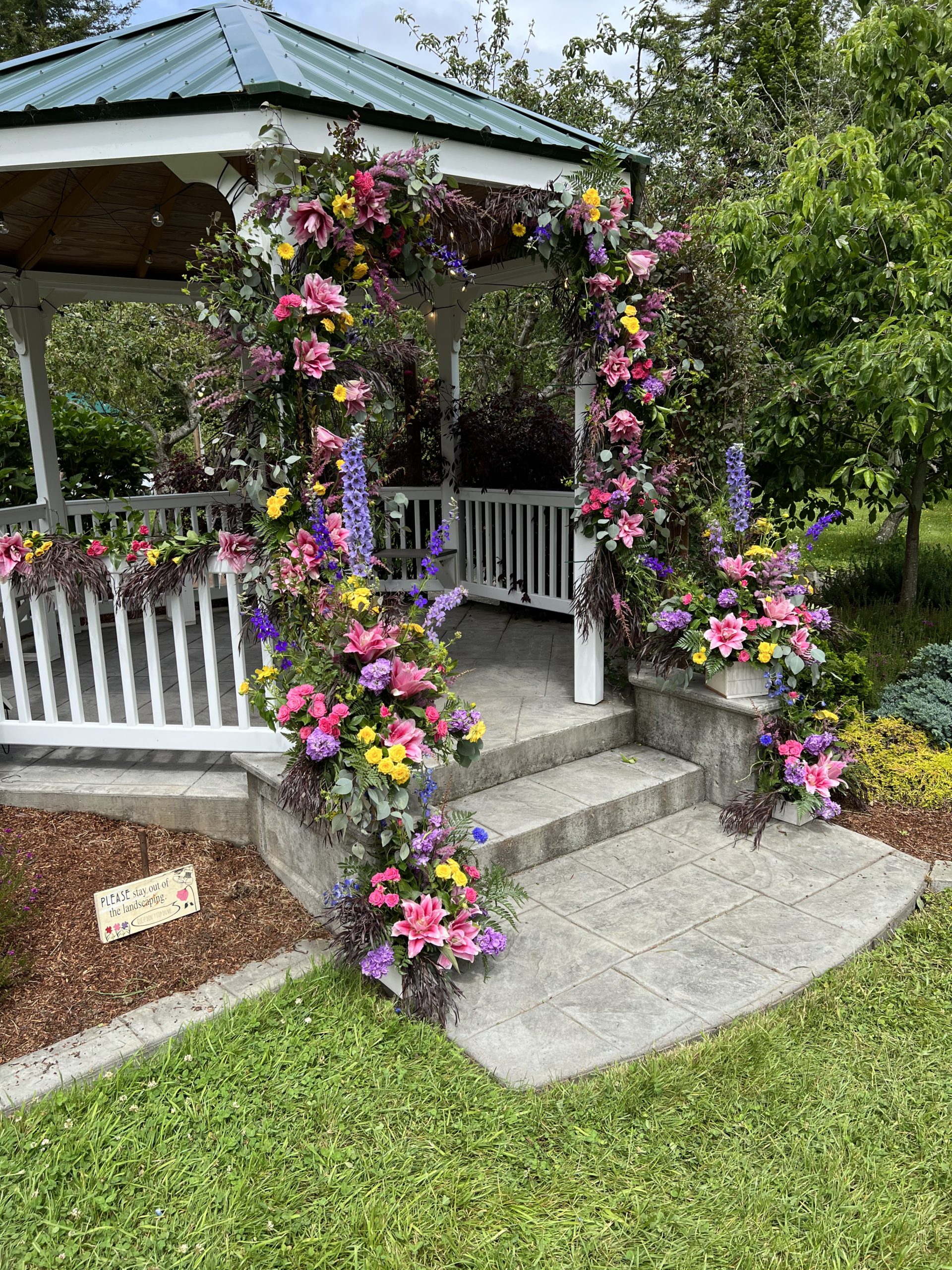 Gazebo decorated with a mix of real and artificial flowers for a wedding ceremony at Mitchell Grove in Northern California.