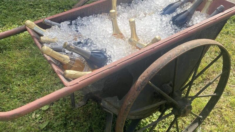 Rustic vintage cart filled with ice and champagne bottles, part of the free outdoor wedding décor at Mitchell Grove’s apple orchard venue in Northern California.