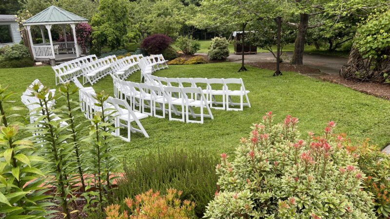 Garden wedding ceremony with chairs facing a large tree and rustic arch, Northern California outdoor wedding
