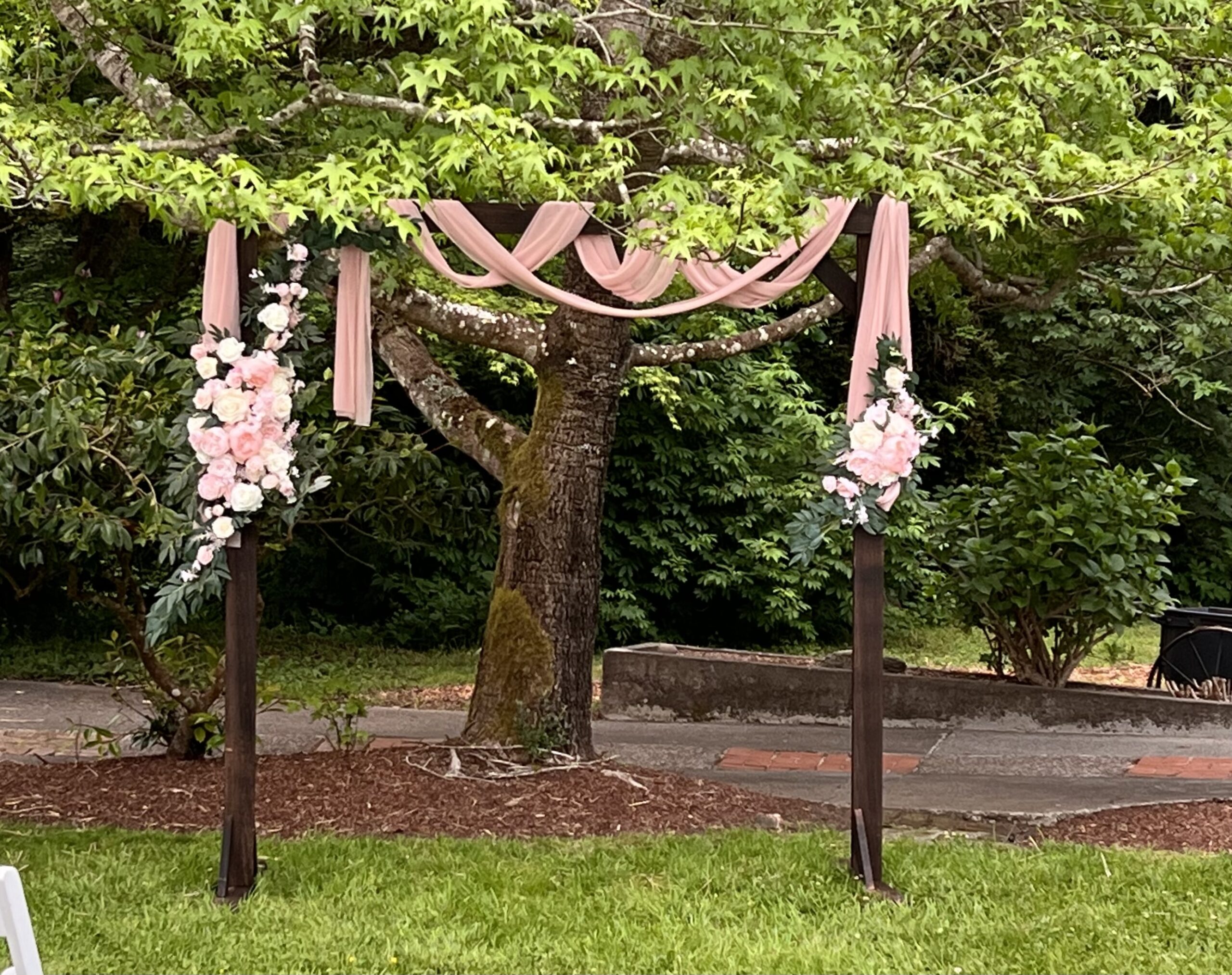 Rustic wooden wedding arch with greenery at Mitchell Grove lending closet