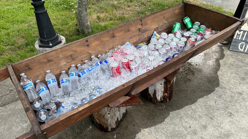 Handcrafted wooden trough cooler from the Mitchell Grove lending closet, filled with ice and bottled drinks for guests at a Northern California orchard wedding. For outdoor use only, as it naturally leaks.