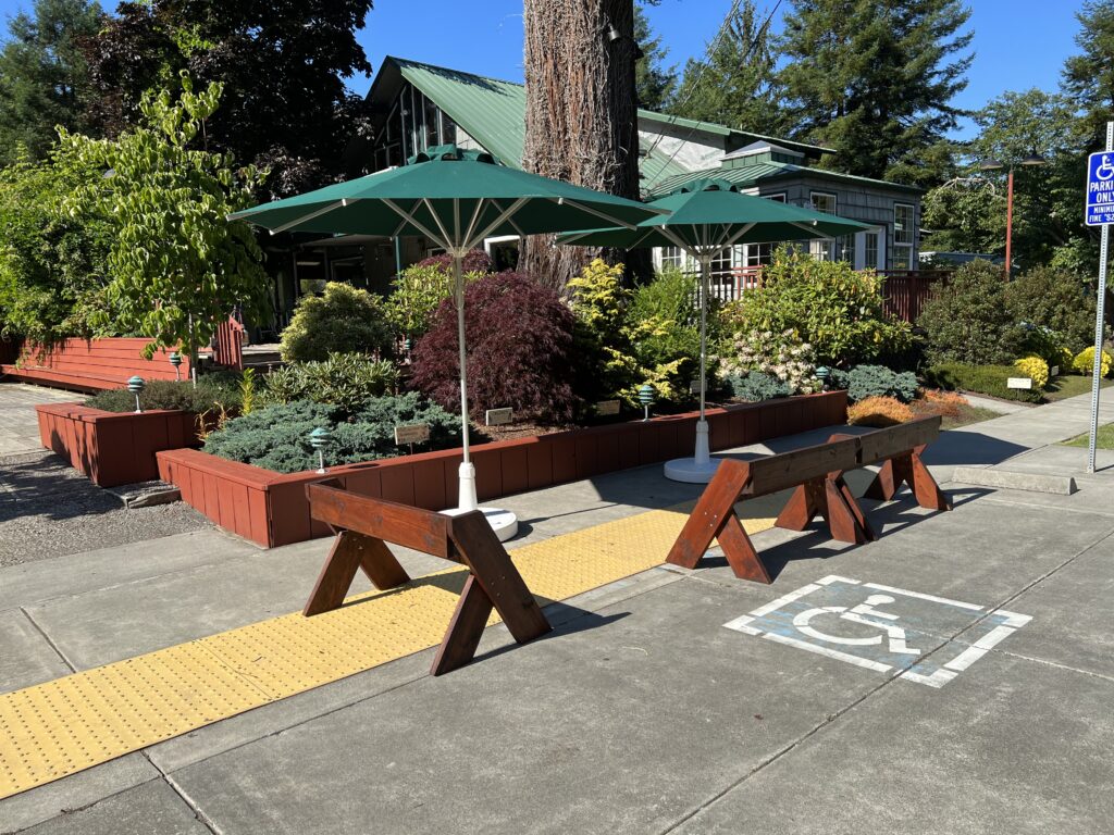 Benches and umbrellas set up in a shaded social area at Mitchell Grove, part of the lending closet for DIY weddings in Northern California
