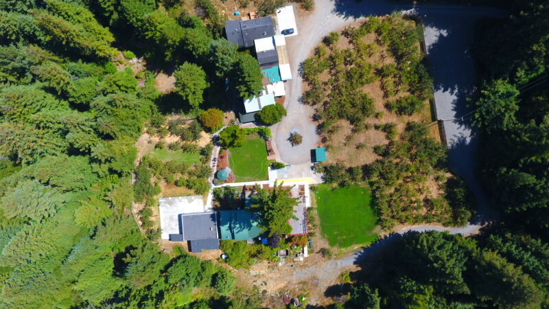 Overhead view of Mitchell Grove orchards showing ceremony areas with green grass among summer fields, useful for out-of-town couples planning weddings in Humboldt County, California.