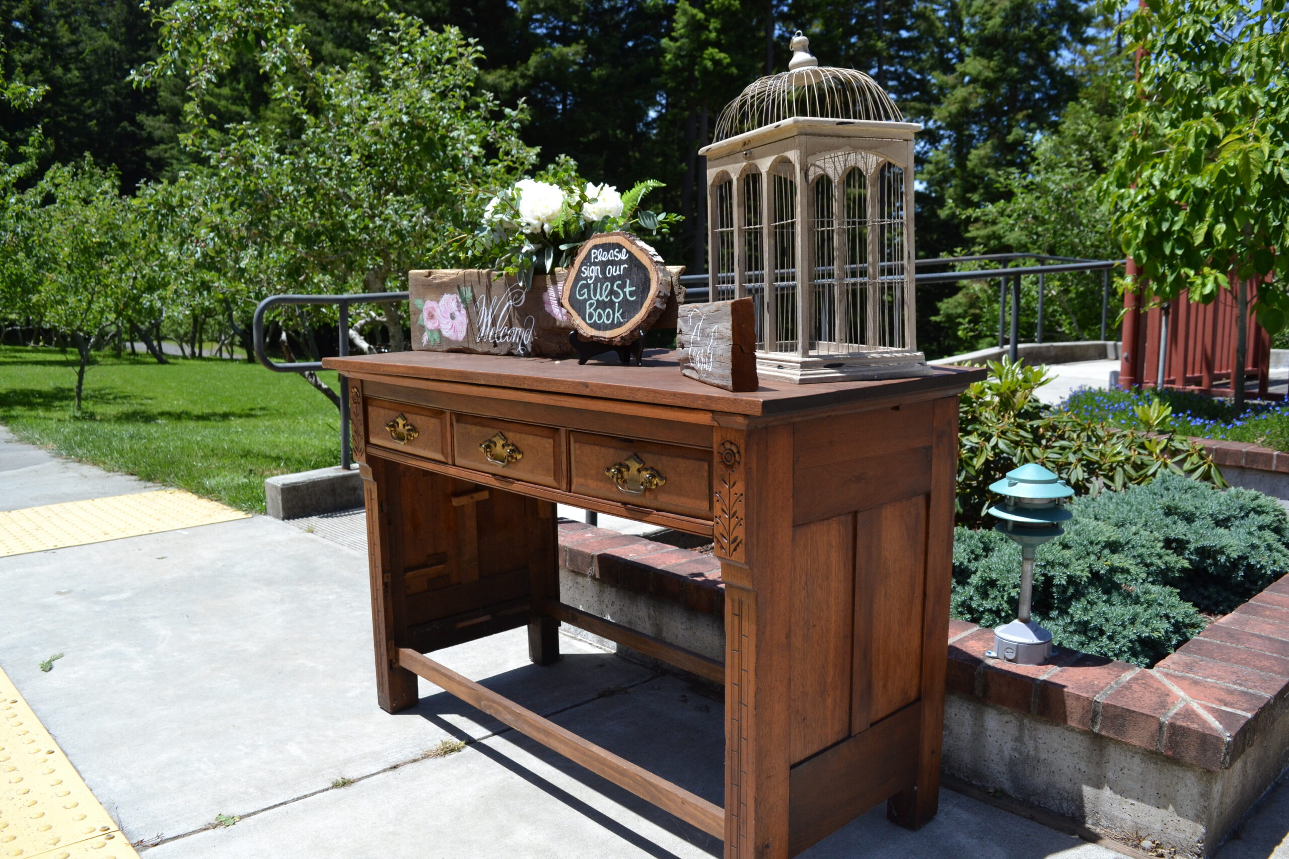 Brown vintage desk with wedding decorations on top, part of Mitchell Grove’s DIY wedding lending closet in the redwoods