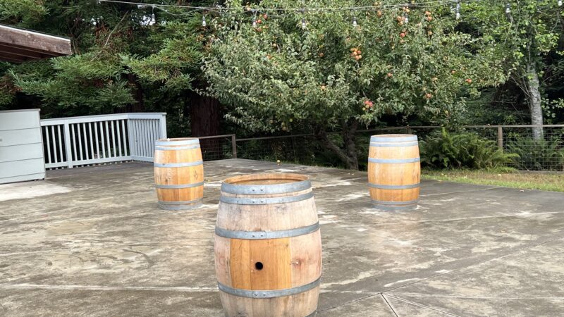 Wine barrels on the patio at Mitchell Grove, used as rustic cocktail tables or bases for venue umbrellas