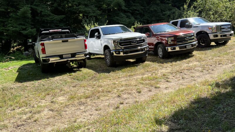 Row of trucks parked on the grass at Mitchell Grove, showing easy guest parking for outdoor weddings in Northern California